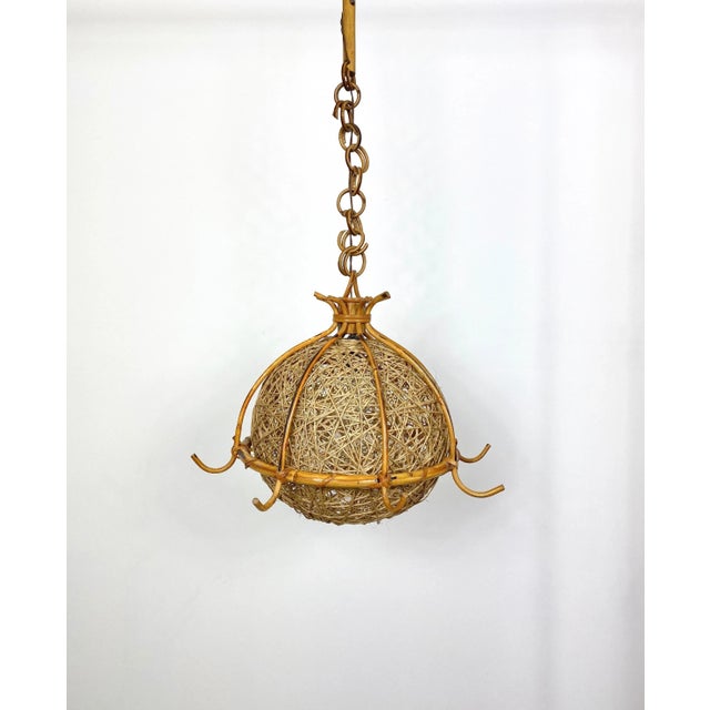 Chandelier in a bamboo rattan structure and cane rope elliptical removable lampshade, with a chain rattan pendant. A...