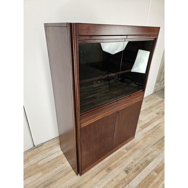 An elegant 1970s Italian display cabinet made of rosewood veneer, featuring a rigorous, geometric design typical of...