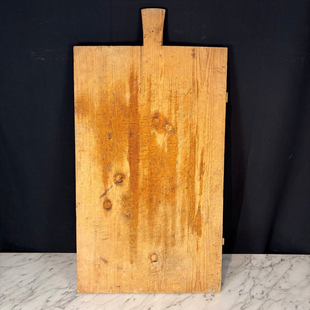 French bread board or charcuterie board, handcrafted from solid hardwood pine with a shaped handle and a warm, naturally...