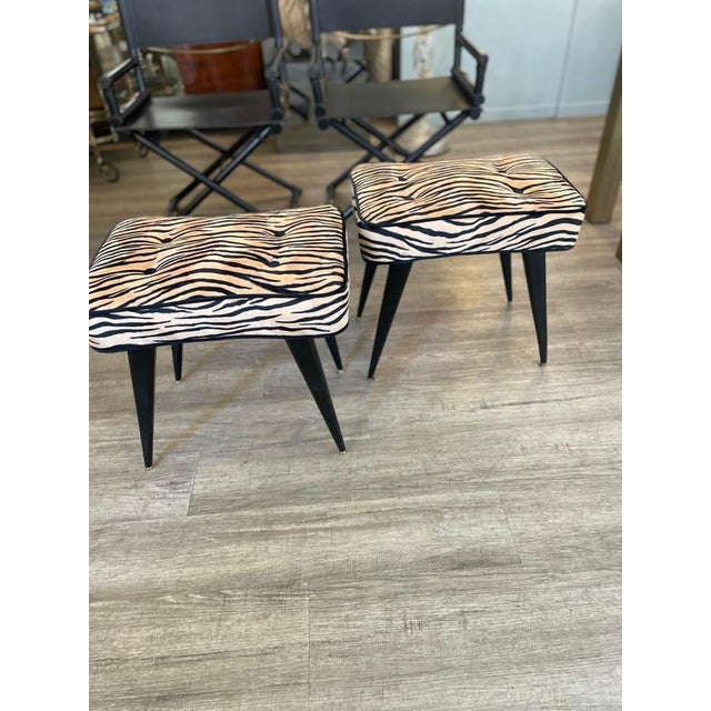 A pair of ebony benches with brass legs from the 1950s. The benches have new padding and have been reupholstered with...