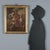 Oil on canvas. A woman sitting on the side of the road, breastfeeding her child, breaks a loaf of bread to share with...