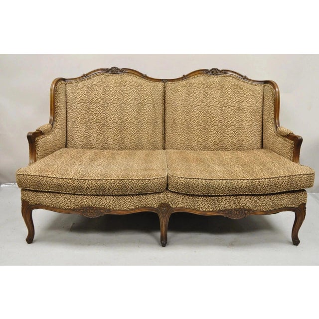 Vintage French Country Louis XV Style Carved Walnut Wingback Sofa Settee. Item features cheetah print microfiber fabric,...