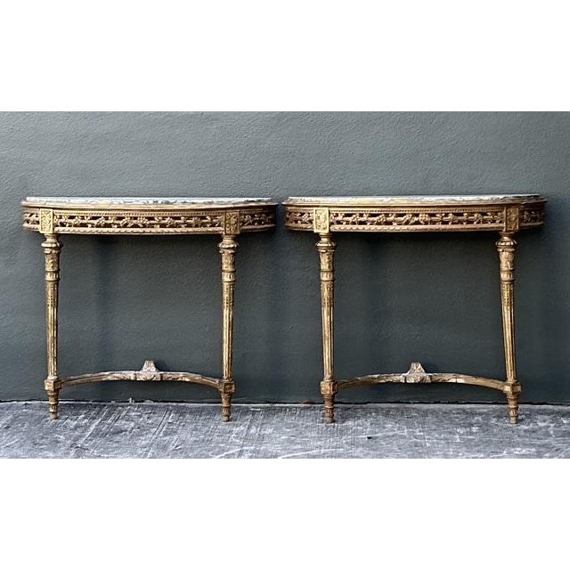 This exquisite pair of vintage French Louis XVI style demilune console tables exudes timeless neoclassical elegance and...