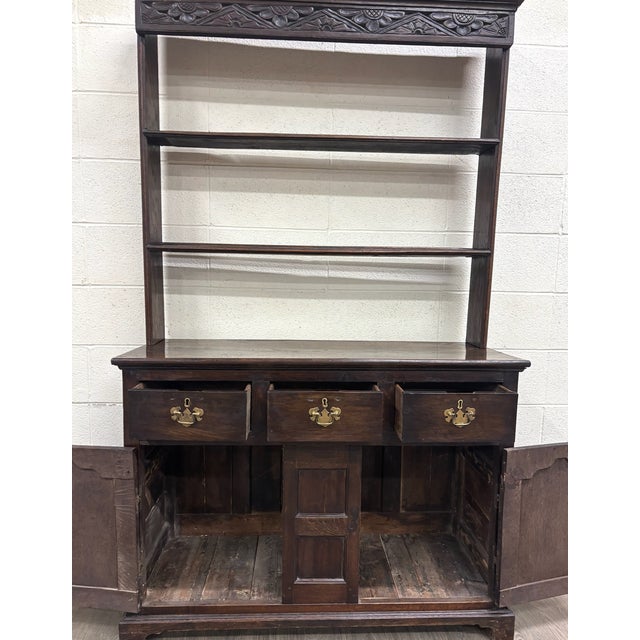 This is a stunning antique English oak pewter cupboard or Welsh style dresser featuring an architectural upper plate rack...