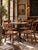 This collection of four antique primitive chairs embodies rustic farmhouse charm. Each chair features a plank seat with a...