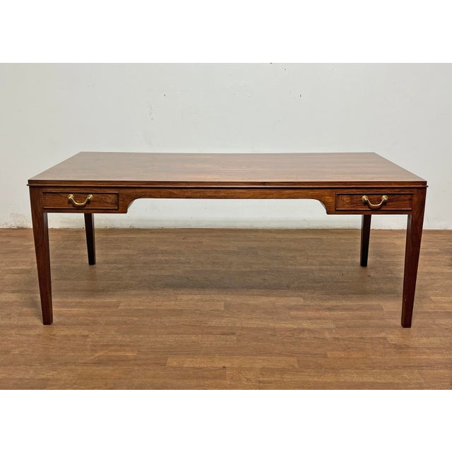 A rosewood desk-form coffee table with flanking storage drawers along each side of its length, fitted with brass bail...
