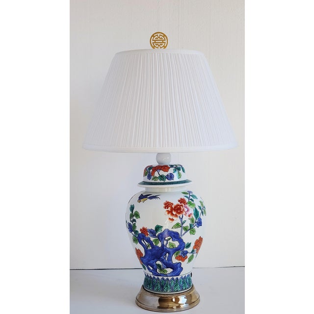 A very pretty porcelain ginger jar table lamp with dome lid, pleated shade and brass Asian finial. Featuring flower...
