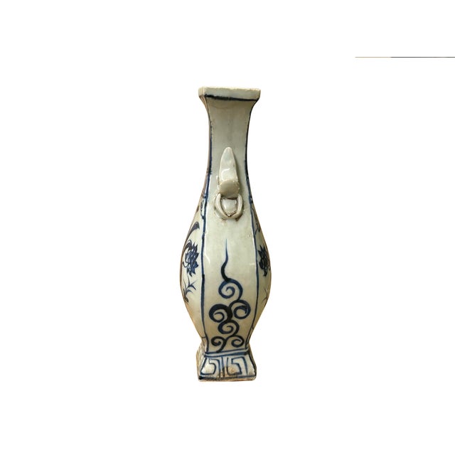 This small porcelain vase features a classic blue-and-white design characterized by a pear-shaped body, a slender neck,...