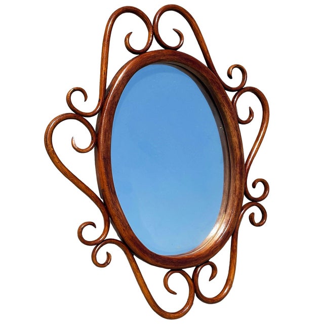Late Victorian Thonet style scrolling bent oak oval wall mirror features a rich brown wooden bentwood or hand-wrapped...