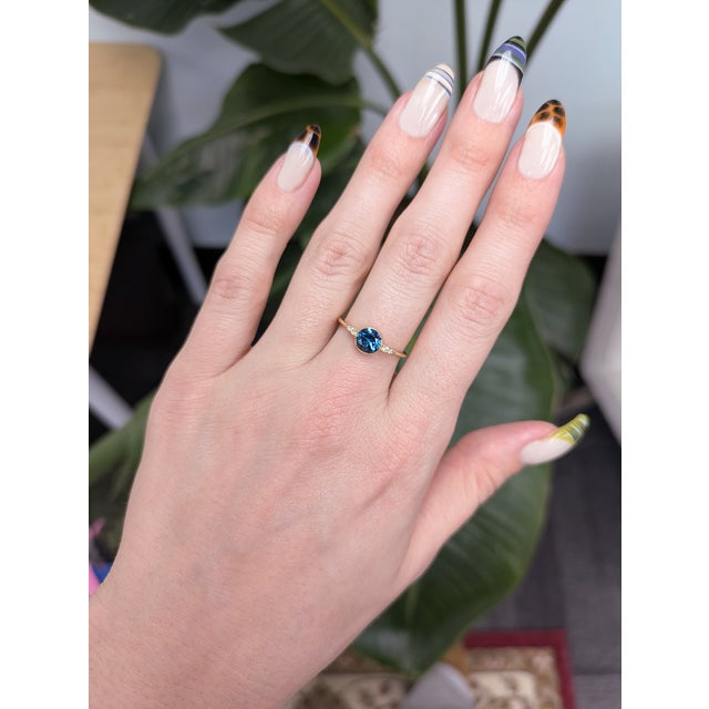 Elegant London Blue Topaz ring accented with natural diamonds, showcasing a rich, captivating blue hue. Crafted in solid...