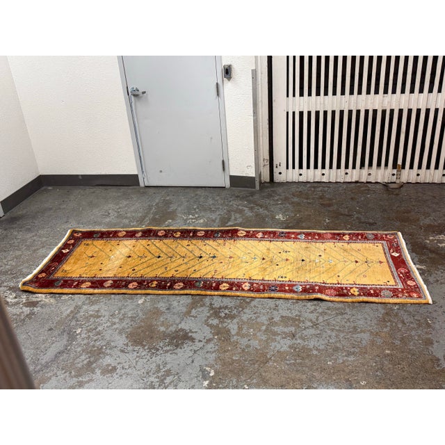 Design Plus Gallery presents a 3ft1in × 9ft4in Vintage Hand Knotted Wool Runner. This wool runner displays a golden field...