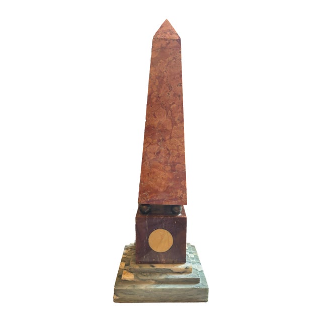 Vintage Grand Tour style marble obelisk. Features a carved rouge marble tower supported by ball feet, mounted on a dark...