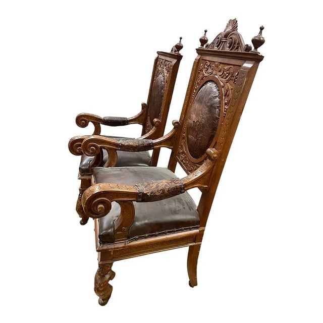 Pair of antique Victorian Renaissance Revival carved walnut armchairs, featuring ornate scrollwork, pierced crest rails,...