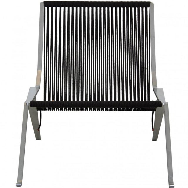 Poul Kjærholm PK-25 lounge chair upholstered with a seat of black flagline and a frame of brushed steel. The chair is from...