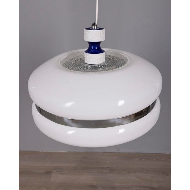 Chandelier with chromed metal structure and decorated ceramic, large white plastic lampshade, Italian design, 1970s. Up to...