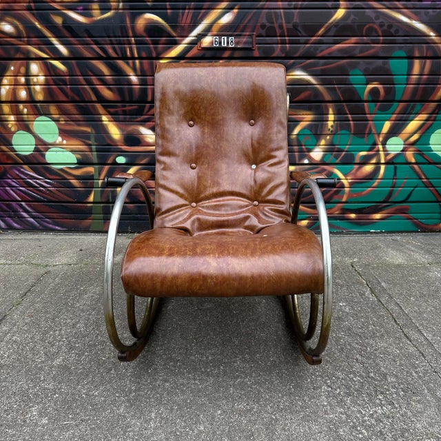 This sculptural rocking chair was designed by Lee Woodard. It is constructed of brass plated steel with solid brass...