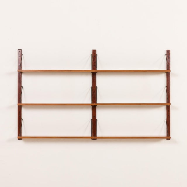 The minimalist Scandinavian mid-century shelving unit is a modular system with shelves arranged in two rows, creating an...