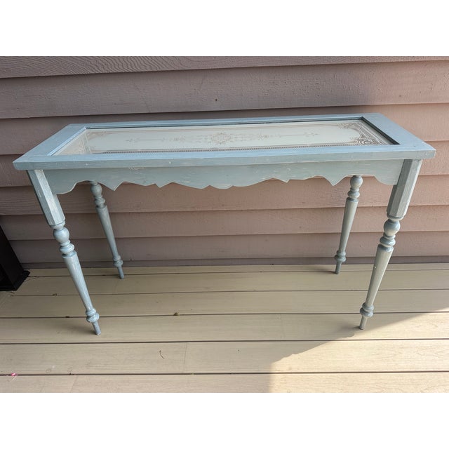 Lovely hand carved wood console table with an etched glass top. Painted in a serene blue gray. A fancy rustic look!