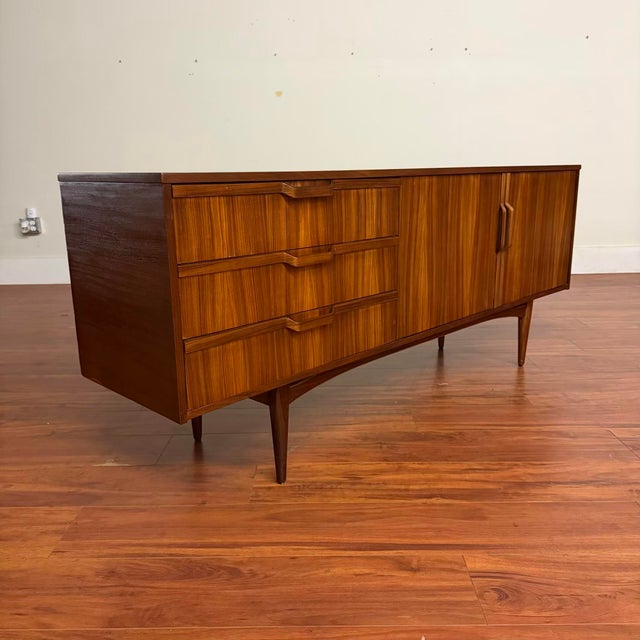 Vintage mid-century sideboard with bent wood pulls, tapered legs and stretcher base, made in the U.K. by Royal Heritage...