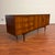 Vintage mid-century sideboard with bent wood pulls, tapered legs and stretcher base, made in the U.K. by Royal Heritage...