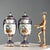 A pair of Sèvres porcelain lidded vases with gold and cobalt blue decorations. The vase's belly features a scene with...