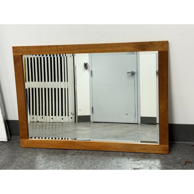 Design Plus Gallery presents a Contemporary Beveled Glass Mirror. The rectangular mirror is bordered by broad wood rails...