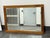 Design Plus Gallery presents a Contemporary Beveled Glass Mirror. The rectangular mirror is bordered by broad wood rails...