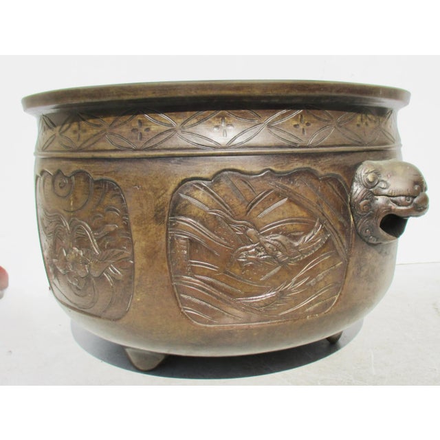 Large Bronze Japanese hibachi on three feet two lion head handles. This has six side panels showing dragons, phoenixes,...