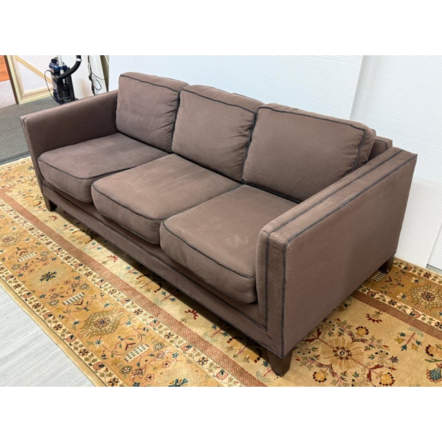 Design Plus Gallery presents a Brown Sofa with Contrast Trim from Mitchell Gold + Bob Williams. The sofa has a dark brown...