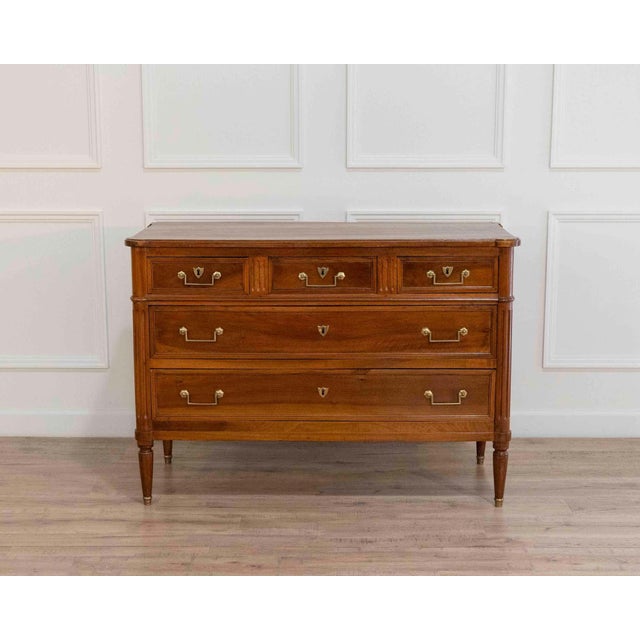 A well-proportioned Louis XVI–style chest of drawers crafted in walnut, dating from the early 19th century. The façade...