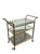 Elegant vintage Regency-style three-tier bar cart featuring a brass frame with clear glass shelves and oversized spoked...