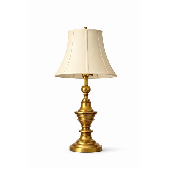 Classic pair of solid brass table lamps by Stiffel, featuring elegant turned profiles, warm original patina, and tailored...