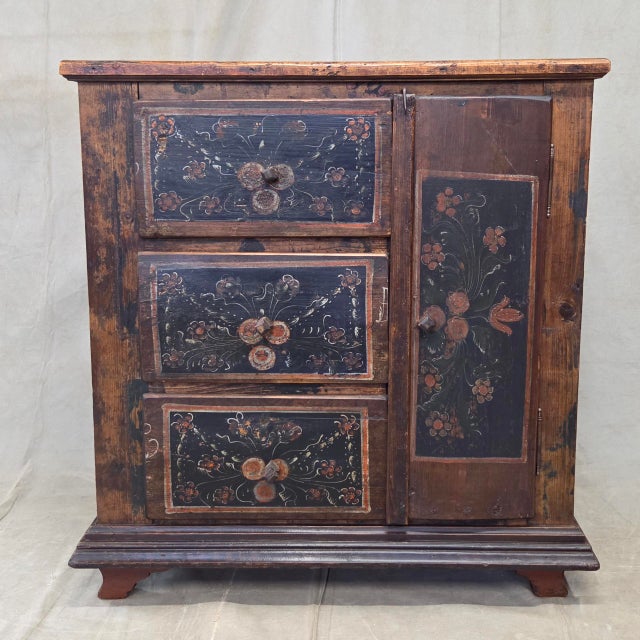 A charming and functional antique late 1800s or early 1900s Romanian pine cupboard that was hand painted in floral motifs...