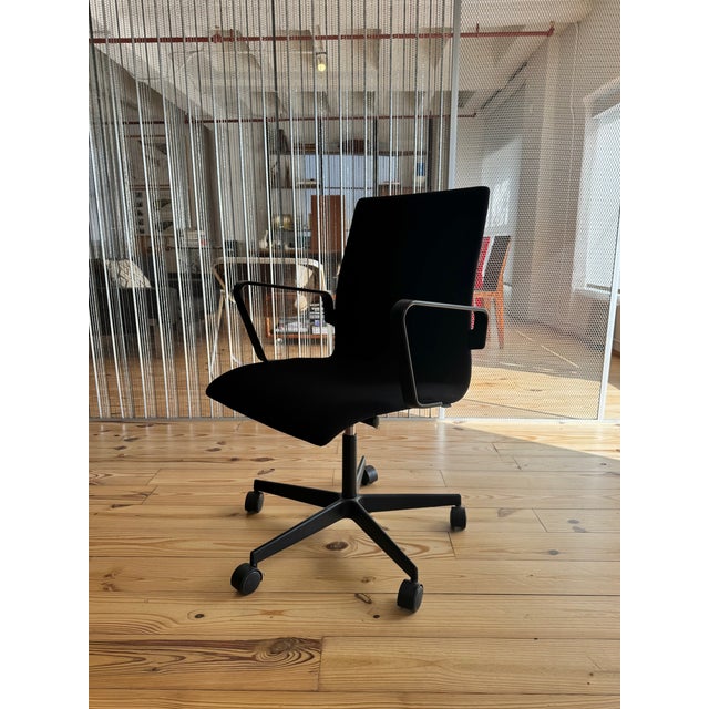 Arne Jacobsen Oxford low-back chair, a classic design combining comfort and timeless style. This version features a sleek,...