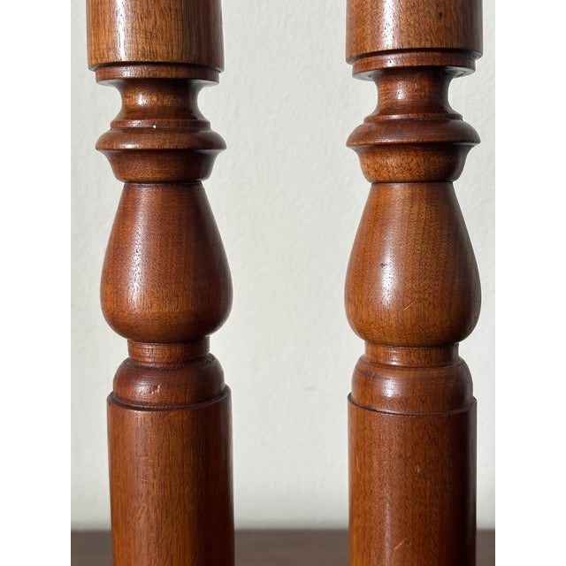 Pair of vintage hand-turned wooden candlestick holders with a warm brown finish and bulbous spindle shapes. 13”h 3/4”...