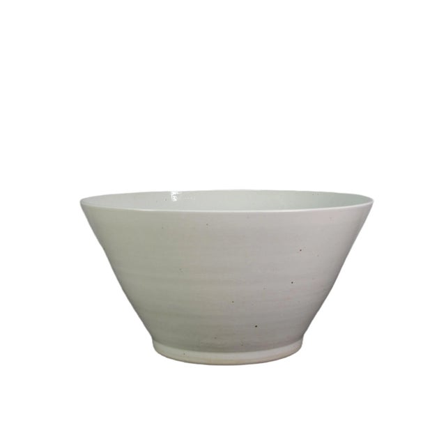 This large white cone shape bowl is handmade and each piece has its unique and natural variance. The bowl features a...
