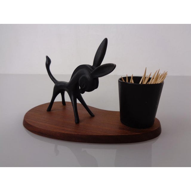 Black metal donkey in the style of Walter Bosse. Mounted on a teak stand.