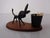 Black metal donkey in the style of Walter Bosse. Mounted on a teak stand.