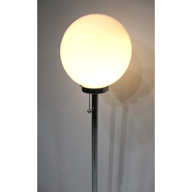 A chrome 1970's space age floor lamp with white glass ball shade, chrome staff and weighted round chrome base. A nice...