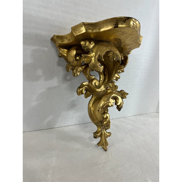 Single antique carved floral wall bracket with gold gilt finish and plate slot. Approximate size of usable top of shelf is...
