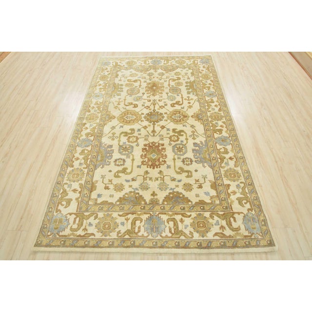 This traditional Oushak rug is hand-knotted with an all-wool pile on a cotton foundation. This rug is new and in excellent...