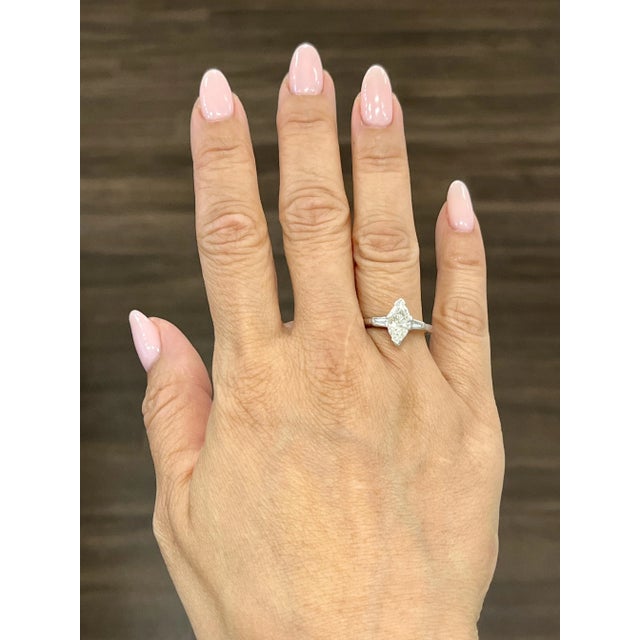 This stunning ring features a 1.33 ct marquis set in platinum with 2 baguettes on the side. The diamonds boast a color of...