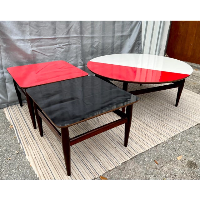 A Set of one Vintage Mid Century Modern Cocktail/ Coffee and two Accent Side Tables. Circa 1960s Feature contrasting red,...