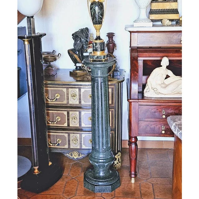 Column in molded and carved green marble, the barrel decorated with grooves, the lower part carved with large Godrons and...