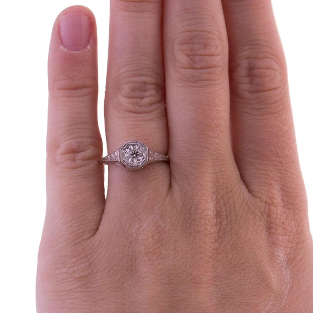 Octagon bezel engagement ring. The ring features an approximately 0.33 carat white diamond, set in a detailed 14k white...