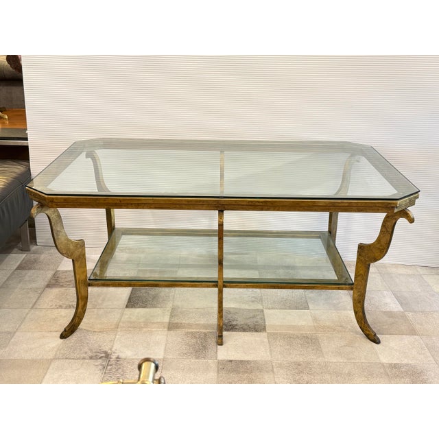 Design Plus Gallery presents a glamorous Swaim Hollywood Regency cocktail table, featuring a gold gilded iron frame with...