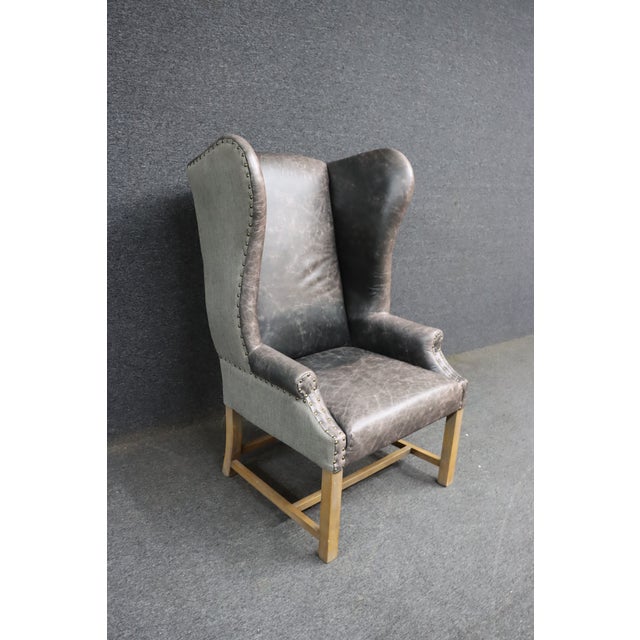 Classic wingback chair attributed to Restoration Hardware. Upholstered in distressed leather with a contrasting fabric...