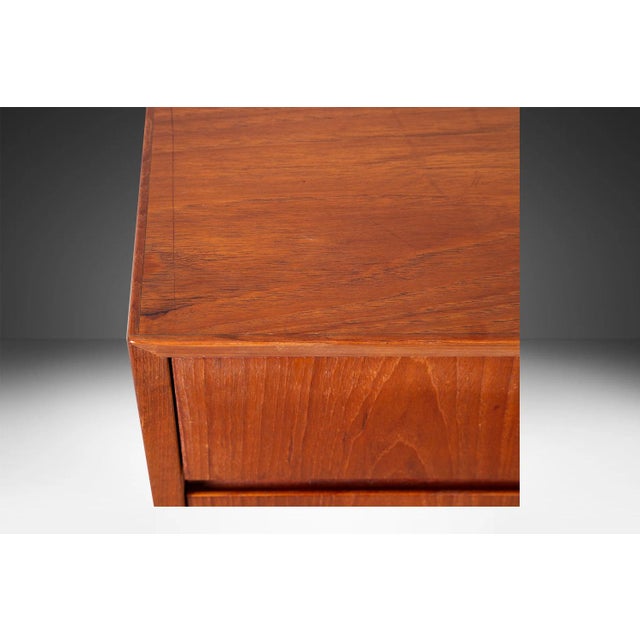 Attractive long low Danish modern sleek smooth face teak 8 long low dresser. This is a very simple yet modern 8 drawer...