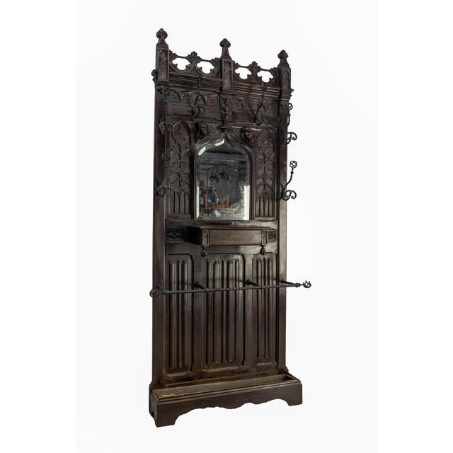 French late 19th century coat and hat rack hall stand. Hand carved oak, wrough iron and beveled mirror. The gothic style...