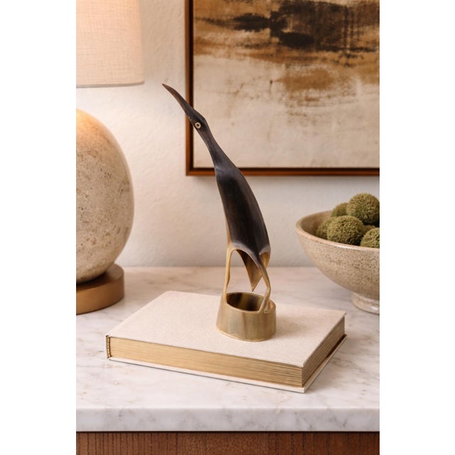 This elegant sculptural figure is a finely carved horn bird, rendered in a sleek, elongated modernist form. The design...